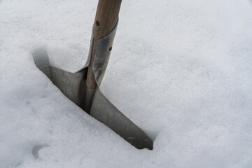 雪に刺さったスコップのアップ