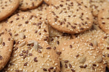 Cereal crackers with flax and sesame seeds as background, closeup