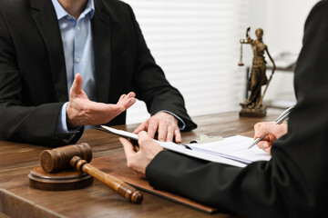 Woman signing document in lawyer's office, closeup