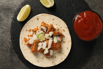 Delicious taco with vegetables, meat and ketchup on grey textured table, top view