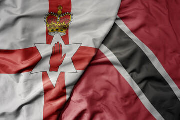 big waving national colorful flag of trinidad and tobago and national flag of northern ireland .