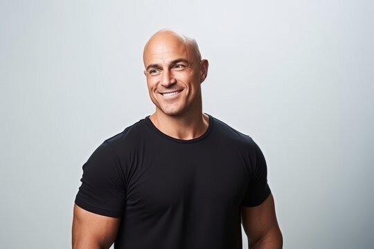Portrait of a smiling middle-aged bald man in a black t-shirt.
