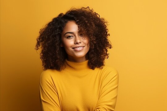 Portrait of a smiling african american woman in yellow sweater over yellow background