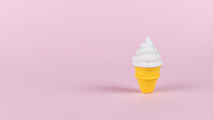 A cup of creamy ice cream on a pink background.