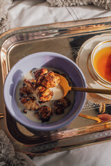 lilac bowl with handmade mini croissant cereal with blueberry sugar and golden spoon on silver tray