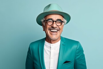 Portrait of a happy senior man in a green suit and hat.