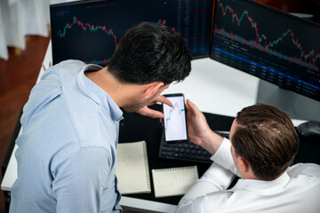 Investor stock officer focusing on dynamic exchange rate database on smartphone, comparing with...