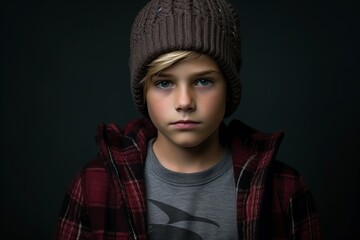 A portrait of a teenage boy wearing a warm hat and a plaid shirt.