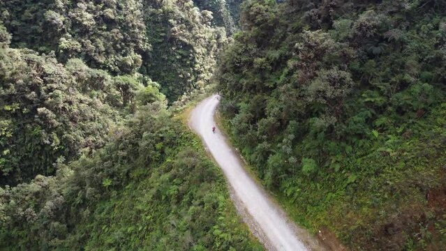 Aerial tracks mountain biker bicycling down Death Road in Bolivia mtns