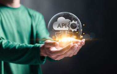 API, Application programing interface concept, software development tool, information technology. Person holding globe and API icon on virtual screen.