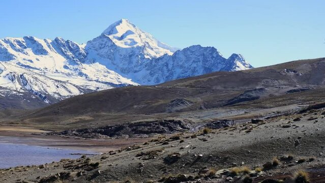 Pan across high altiplano landscape in snow capped Bolivian Andes mtns, Huayna Potosi