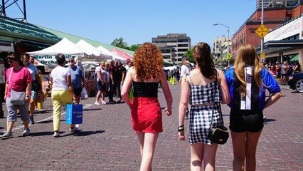 Young women walk through the Pike Place Market