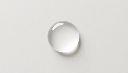 One transparent water drop. White paper background - top view
