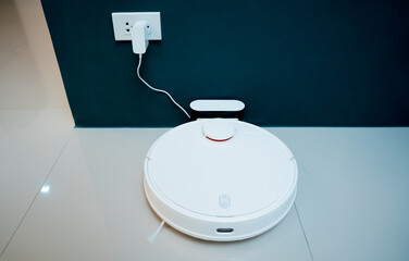 A robot vacuum cleaner at home moving towards the charging station.