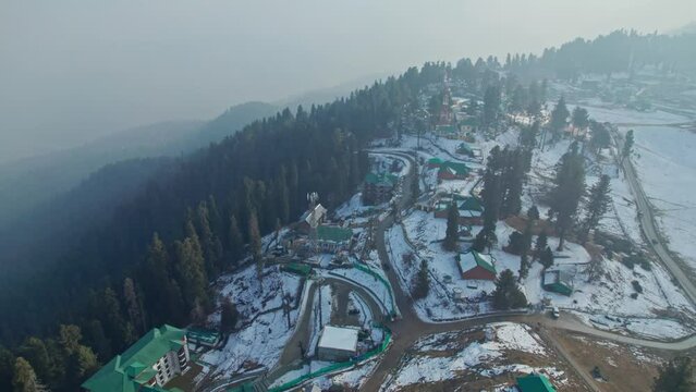 awesome aerial view of gulmarg with houses, trees and snow in winter push in drone shot 4k, jammu and kashmir, india