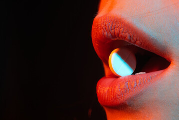 Pill in mouth close up. Woman taking pills, closeup. Sick ill woman holding antidepressant...