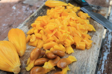 Jackfruit slices on a wooden chopping board on the table