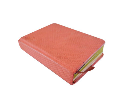 A pink leather-bound journal or book or folder used for notes with a bordered ribbon in the middle, isolated on white background with close up shot.