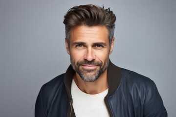 Portrait of a handsome man in a leather jacket, over grey background.