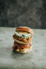 A Close-up of three breakfast sandwiches with eggs, bacon, cheese, and guacamole
