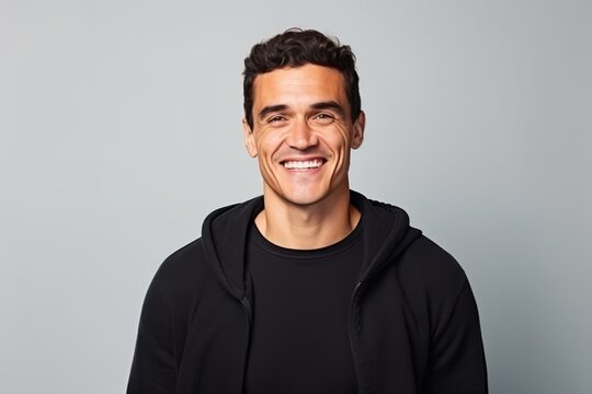 Portrait of a smiling young man in a black hoodie.