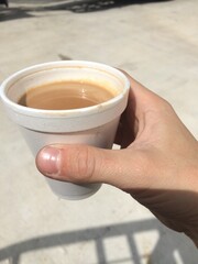Hand Holding Tiny Styrofoam Cup of Coffee in Puerto Rico 