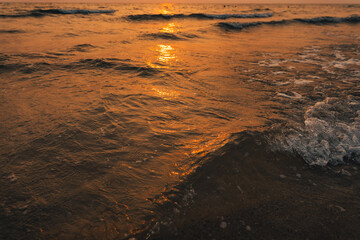 Sunset on the beach,Golden sea waves at sunset