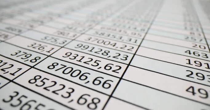 Document with columns of numbers on table in office