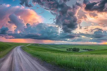 Gordijnen Panoramic view of a serene rural landscape at sunset Featuring an empty country road meandering through lush green fields under a dramatic cloudy sky © Jelena