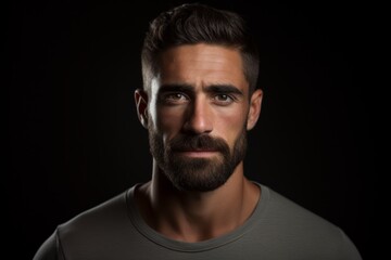 Portrait of a handsome young man with a beard on a black background