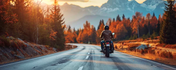 Foto op Canvas Motorcyclist Riding Through Autumn Forest. A lone motorcyclist on a scenic road surrounded by autumn forest and mountains. © AI Visual Vault