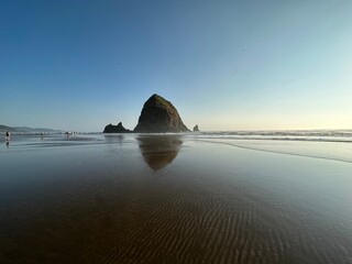 hazy sunset view of Haystack Rock on Cannon Beach in Oregon