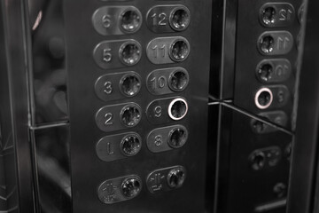 An elevator level button panel, transportation equipment object photo. Photo in dark grey tone.