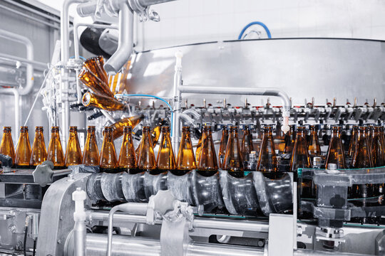 Glass bottle beer bottling filling machine production equipment with automation conveyor line brewery. Concept industrial technology plant of food and drink products