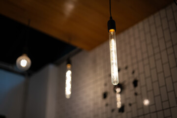 ceiling lighting bulbs are glowing in orange warming shade in dark environment. Interior cozy style...