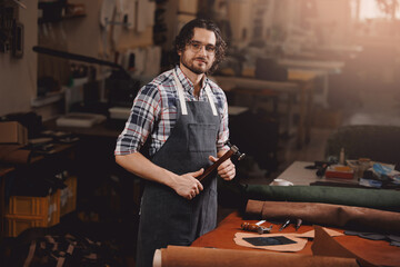 Tailor Artisan cobbler hold tools for leather textile in workshop