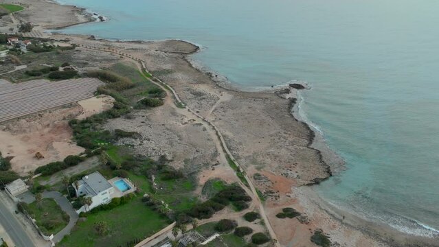 Aerial View of Winding Road Along Cyprus Island Coastline During Tranquil Sunset with Calm Sea - top dowm