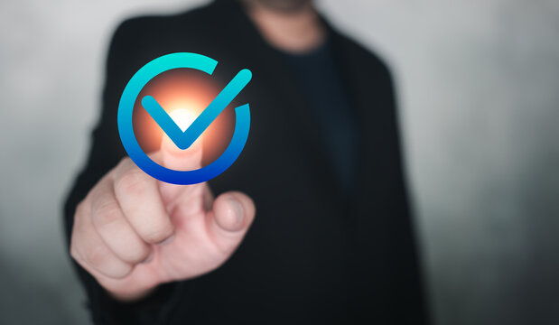 Man in suit hand touch a sign of checkmark to standard quality control certification assurance guarantee. Certification standards, quality control, service assurance for business process automation