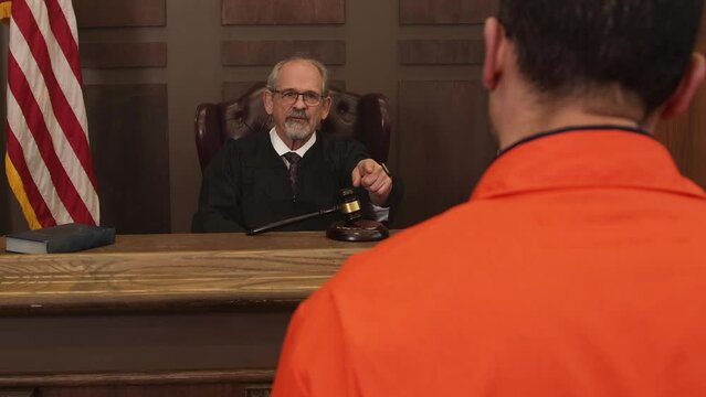 Judge talking to inmate over the shoulder zoom in during court room trial