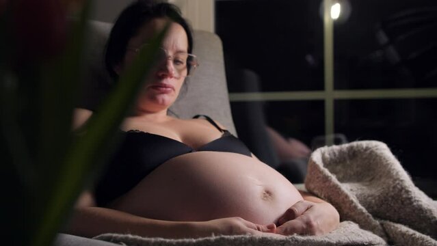 Pregnant woman with evidence of the baby moving in her belly. Static view