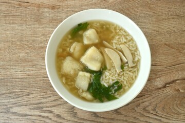 rice porridge with bass fish and slice mushroom topping celery on bowl 