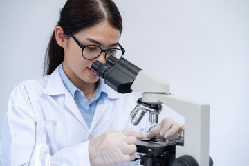 The female scientist is examining petri dishes in the laboratory