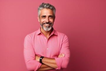 Portrait of a handsome mature man with gray hair in a pink shirt.