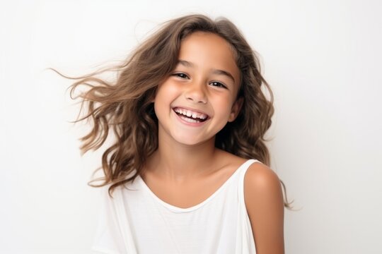 Portrait of a smiling little girl with long hair on white background