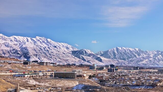 Bright sunny day across the Thanksgiving Point area overlooking Silicon Slopes in Lehi, Utah with majestic mountains behind. Moving up.
