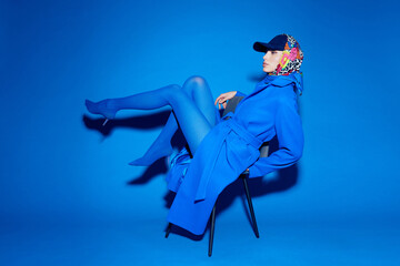 fashion portrait of young elegant woman in blue coat.