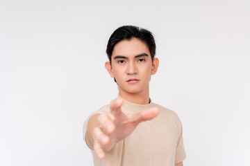 Portrait of a young Asian man reaching out with his hand, symbolizing request, help, or a second...