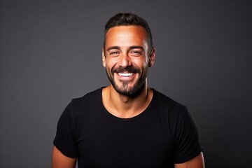 Portrait of a handsome man laughing and looking at camera over grey background - obrazy, fototapety, plakaty