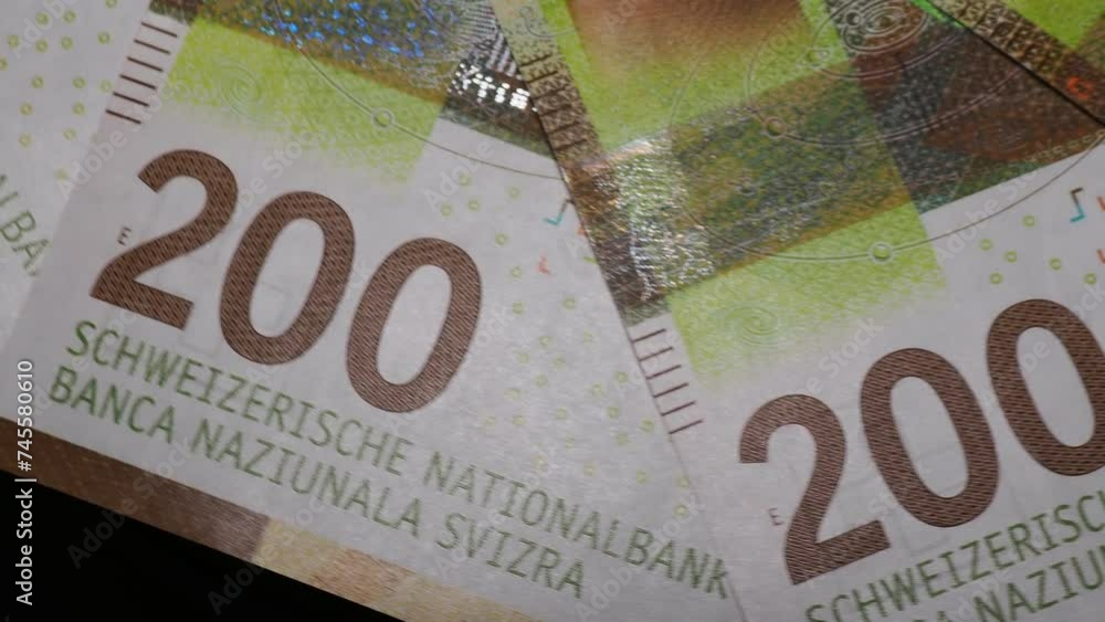 Poster several 200 swiss franc banknotes rotating. detail shot with security features. close up rotating sh