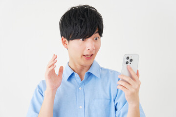 スマートフォンを見て驚く男性　白背景